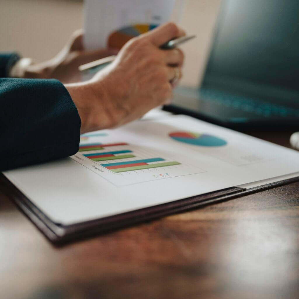 Female hands holding paperwork with statistical financial report on it with graphs and charts